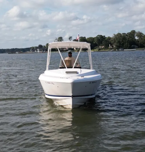  Yacht Photos Pics 2002 Intrepid 323 Cuddy boat cruising on a calm lake under a partly cloudy sky.