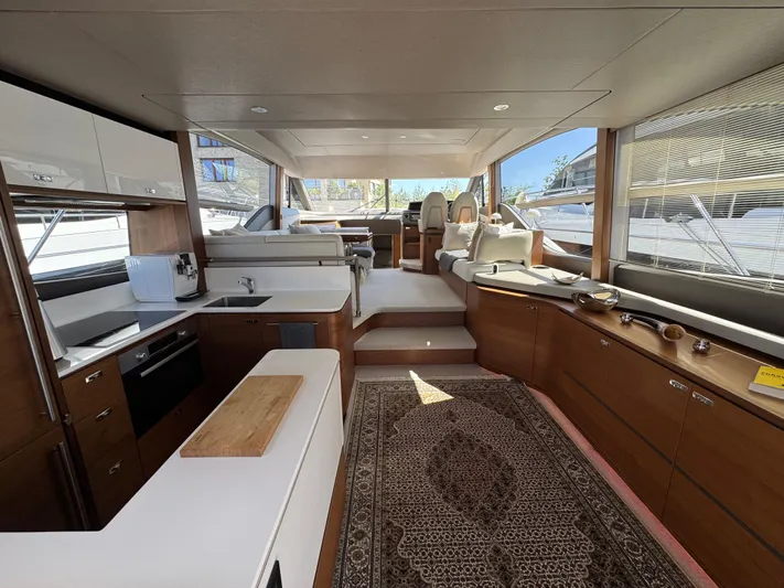  Yacht Photos Pics Luxurious interior of 2020 Princess F55 yacht with modern kitchen and elegant seating area.