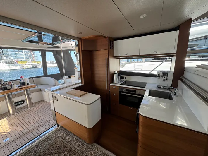  Yacht Photos Pics Luxurious interior of 2020 Princess F55 yacht with modern kitchen and seating area.