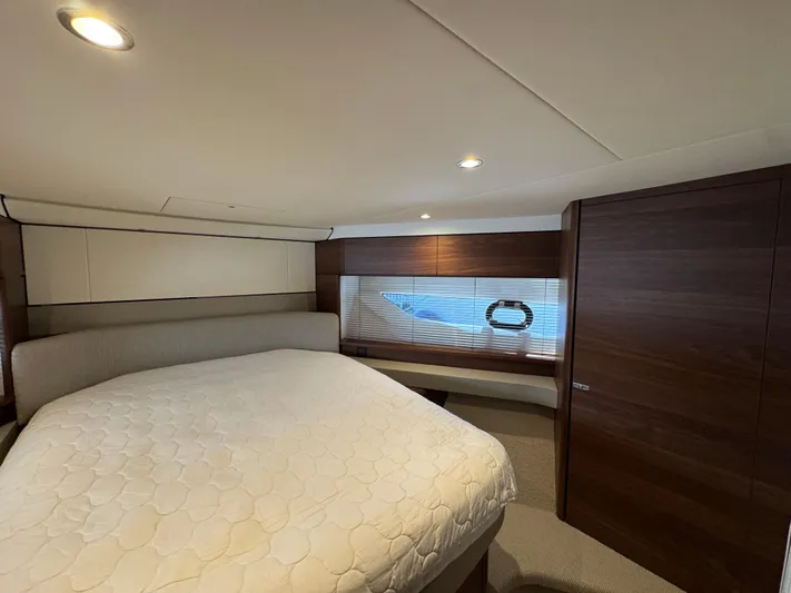  Yacht Photos Pics Luxurious bedroom interior of 2020 Princess F55 yacht with elegant wood finishes.