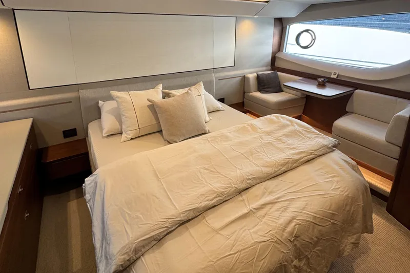  Yacht Photos Pics Luxurious bedroom interior of 2020 Princess F55 yacht with elegant bedding and seating area.