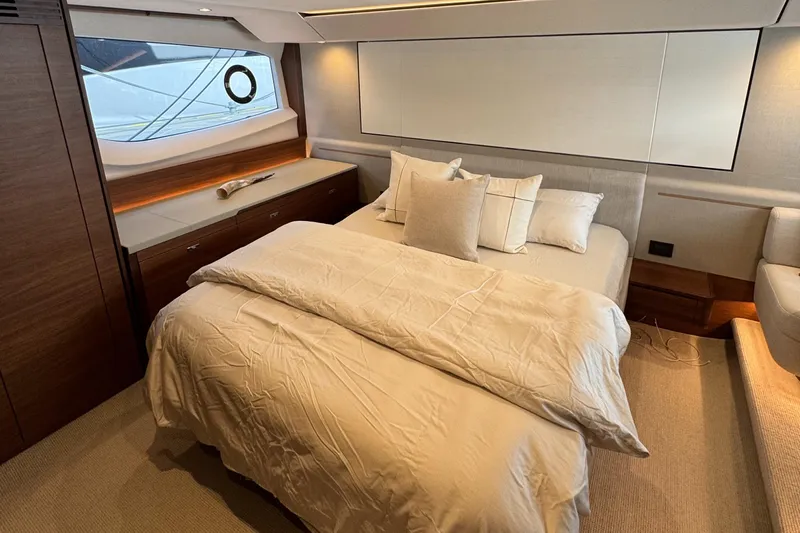  Yacht Photos Pics Luxurious bedroom interior of 2020 Princess F55 yacht with elegant bedding and wooden accents.
