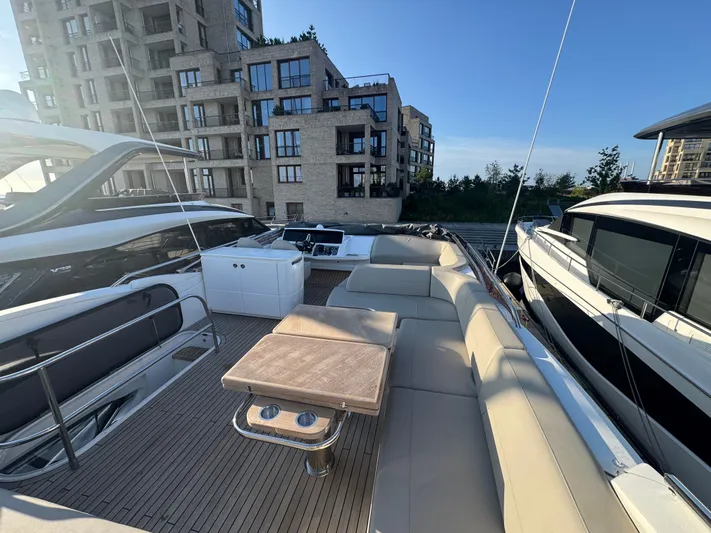  Yacht Photos Pics Luxurious 2020 Princess F55 yacht with spacious deck, docked near modern buildings.