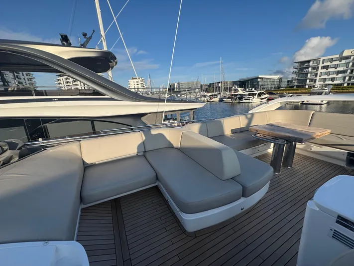  Yacht Photos Pics Luxurious 2020 Princess F55 yacht deck with elegant seating and table, docked at a marina.