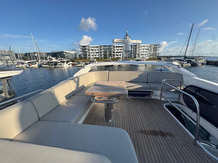  Yacht Photos Pics Luxurious 2020 Princess F55 yacht deck with seating, docked in a marina under clear skies.