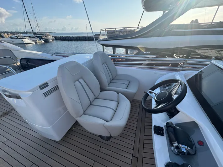  Yacht Photos Pics Luxury yacht Princess F55 helm with plush seating and modern controls, docked at marina.