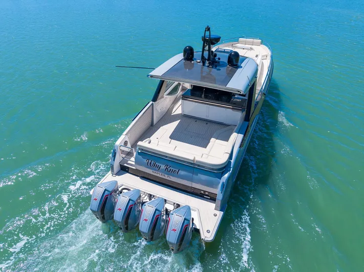 Why Knot Yacht Photos Pics 2022 Azimut 47 VERVE yacht cruising on clear blue water, rear view with four engines.