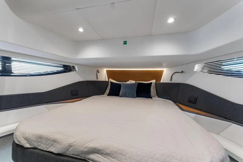 Why Knot Yacht Photos Pics Luxurious interior cabin of 2022 Azimut 47 VERVE yacht with modern bedding and ambient lighting.