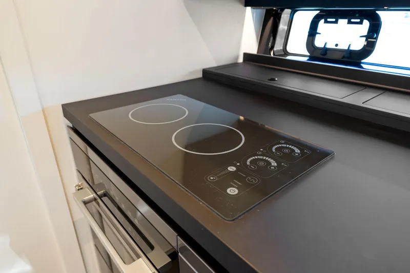 Why Knot Yacht Photos Pics Modern kitchen cooktop on 2022 Azimut 47 VERVE yacht, featuring sleek design and advanced controls.