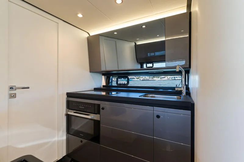 Why Knot Yacht Photos Pics Modern kitchen interior of 2022 Azimut 47 VERVE yacht with sleek cabinetry and appliances.