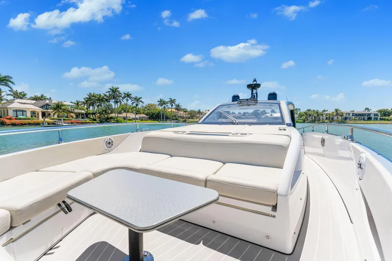 Why Knot Yacht Photos Pics 2022 Azimut 47 VERVE yacht with luxurious seating and table, cruising on a sunny day.