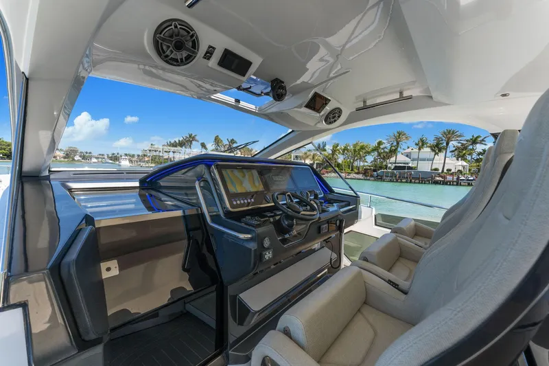 Why Knot Yacht Photos Pics Luxurious 2022 Azimut 47 VERVE yacht cockpit with modern controls and waterfront view.