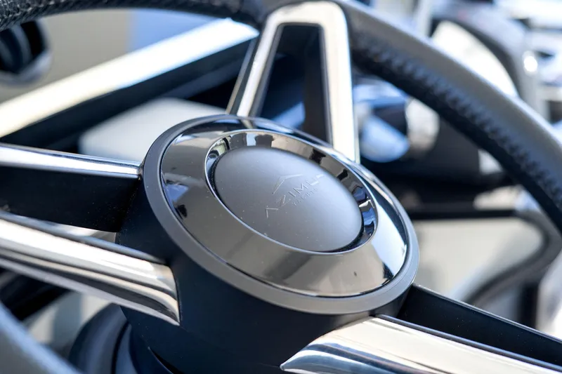 Why Knot Yacht Photos Pics Close-up of 2022 Azimut 47 VERVE steering wheel, showcasing sleek design and craftsmanship.