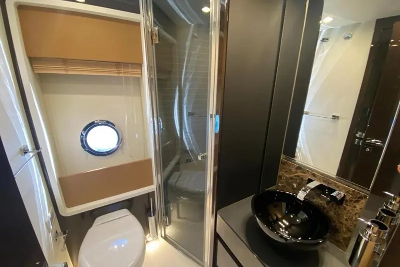 Titta Yacht Photos Pics Luxurious bathroom in 2016 Azimut 77S yacht with modern fixtures and porthole window.