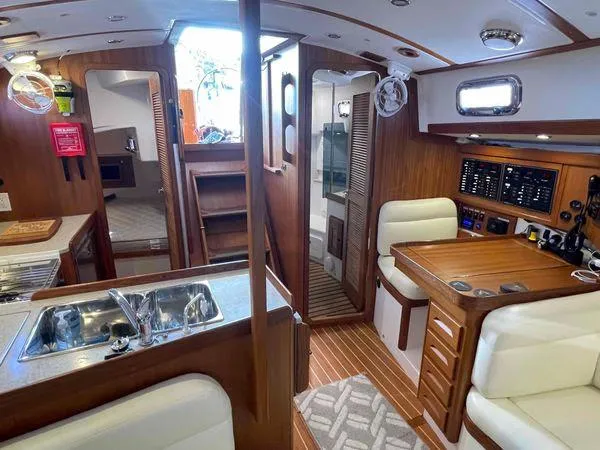 Top O Nok Yacht Photos Pics Interior of 2020 Tartan 395 yacht with wood finish, kitchenette, and seating area.