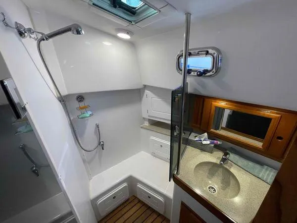 Top O Nok Yacht Photos Pics Modern Tartan 395 yacht bathroom, 2020 model, featuring shower and sink with wooden accents.