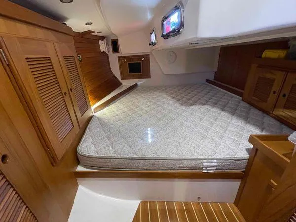 Top O Nok Yacht Photos Pics Cozy cabin interior of 2020 Tartan 395 yacht with wooden finishes and comfortable bedding.