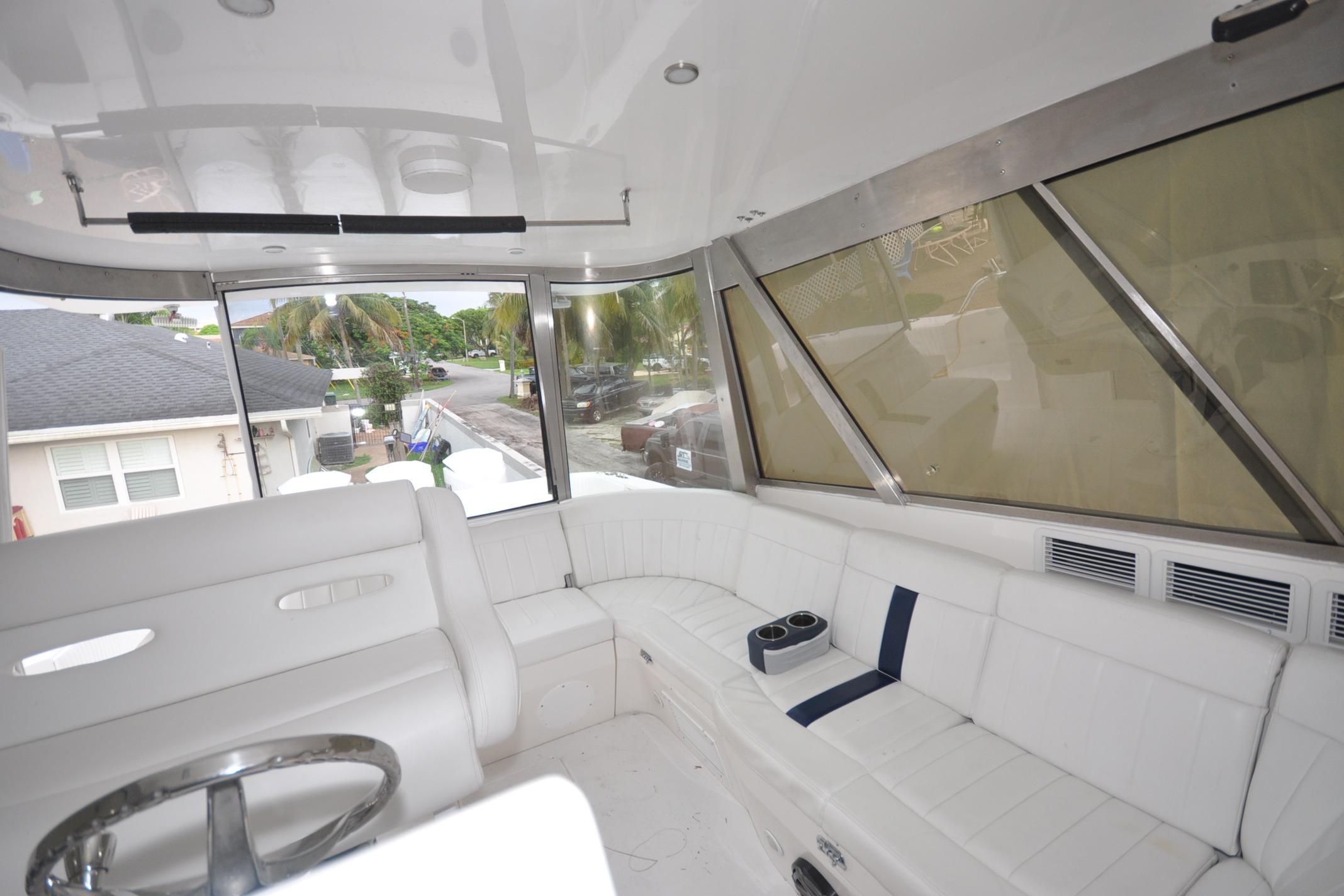 Interior of 2009 Intrepid 430 Sport Yacht with white seating and panoramic windows.