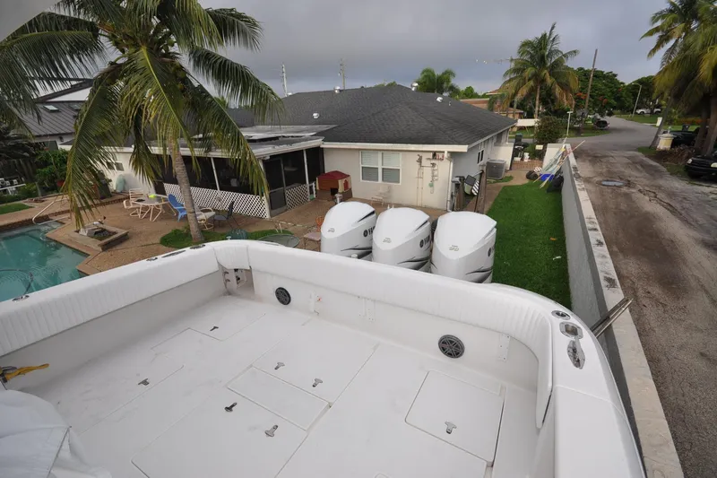  Yacht Photos Pics 2009 Intrepid 430 Sport Yacht docked near a house with palm trees and a pool.
