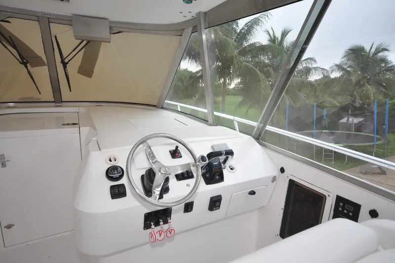  Yacht Photos Pics 2009 Intrepid 430 Sport Yacht helm with steering wheel and controls, overlooking palm trees.