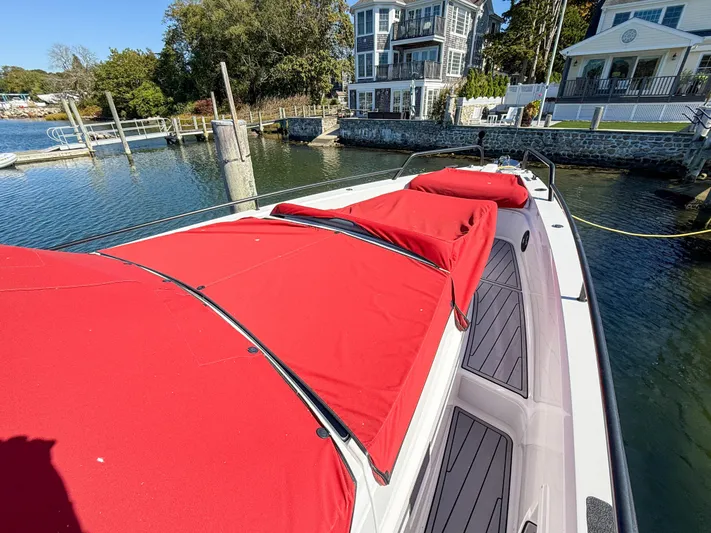  Yacht Photos Pics 2022 Axopar 37 Sun Top with red covers docked near waterfront homes.