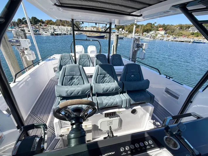  Yacht Photos Pics 2022 Axopar 37 Sun Top boat interior with seating, steering wheel, and waterfront view.