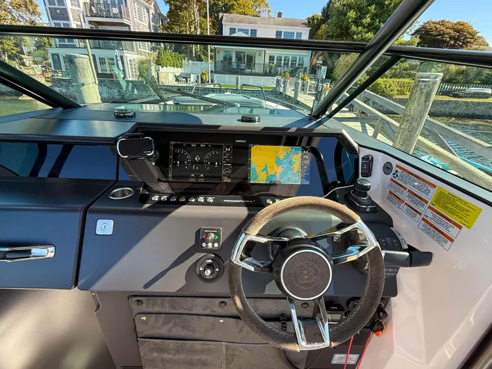  Yacht Photos Pics 2022 Axopar 37 Sun Top boat dashboard with navigation display and steering wheel.