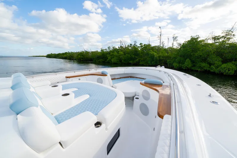  Yacht Photos Pics Luxurious 2026 HCB 56 Suenos GIX yacht with elegant seating, cruising near lush greenery.
