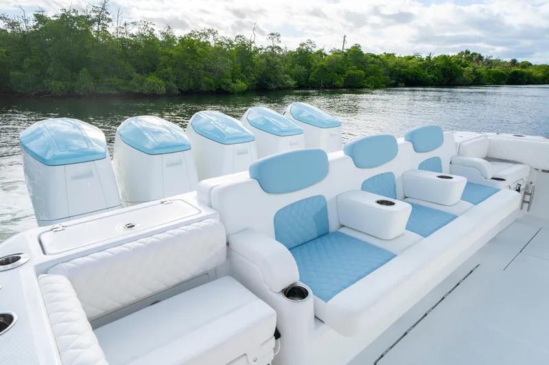  Yacht Photos Pics Luxury seating on 2026 HCB 56 Suenos GIX boat with multiple engines, near lush greenery.