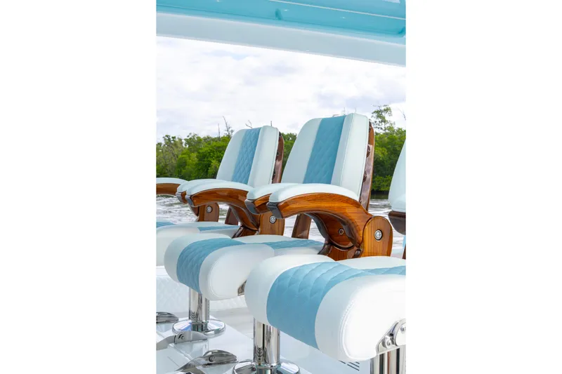  Yacht Photos Pics Luxury seating on 2026 HCB 56 Suenos GIX boat, featuring elegant wood and blue upholstery.