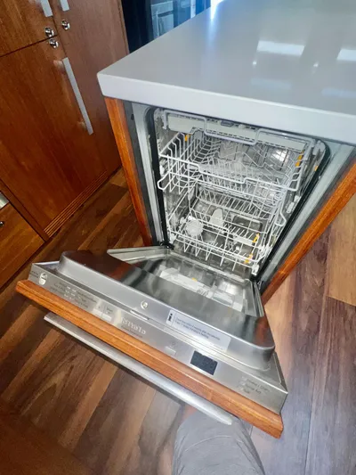  Yacht Photos Pics Open dishwasher in a 2020 Maritimo M51 yacht kitchen with wooden cabinetry.