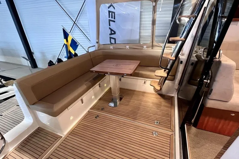  Yacht Photos Pics Luxurious 2023 Nimbus 405 Flybridge yacht interior with seating, table, and staircase.