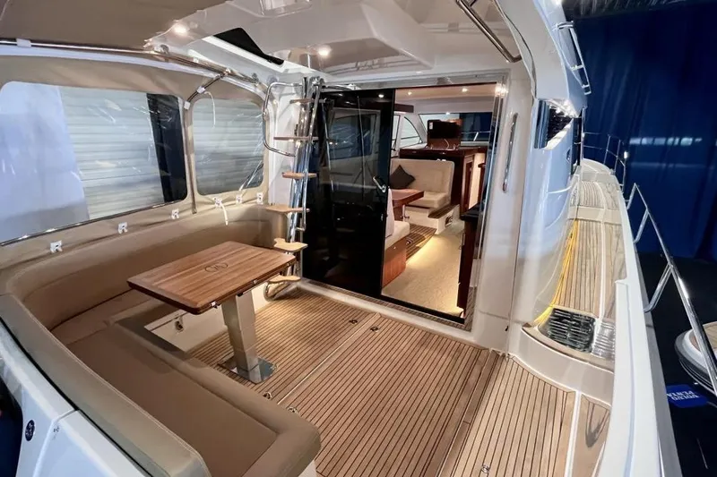  Yacht Photos Pics Luxurious 2023 Nimbus 405 Flybridge yacht interior with elegant seating and wooden flooring.