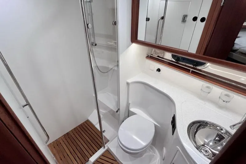  Yacht Photos Pics Luxurious bathroom in 2023 Nimbus 405 Flybridge yacht with modern fixtures and wooden accents.