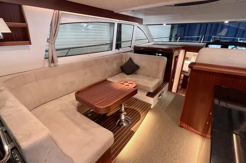  Yacht Photos Pics Luxurious interior of 2023 Nimbus 405 Flybridge yacht with elegant seating and wooden table.
