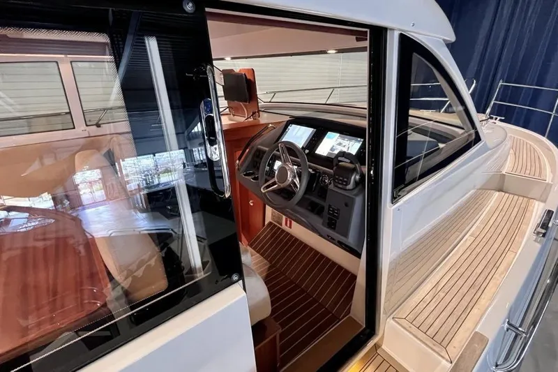  Yacht Photos Pics Interior view of 2023 Nimbus 405 Flybridge yacht cockpit with modern controls and wooden flooring.