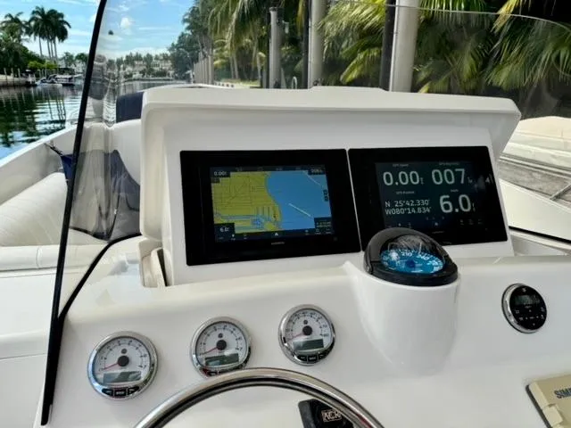 Galore Yacht Photos Pics Intrepid 323 Cuddy 2006 dashboard with navigation screens and gauges, docked near palm trees.