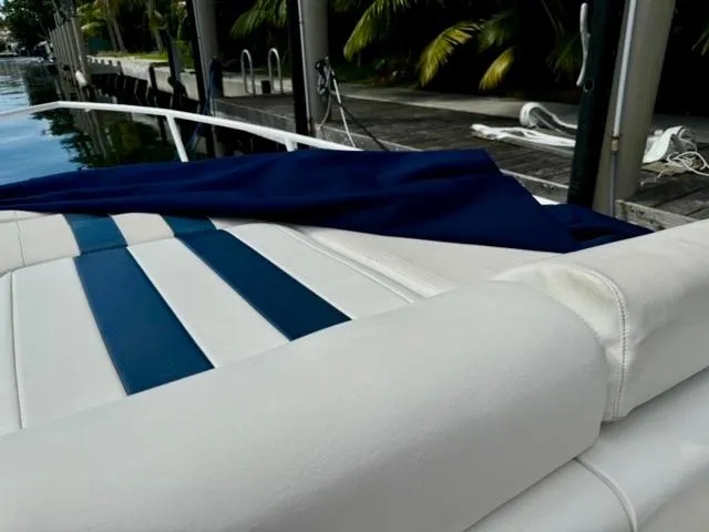Galore Yacht Photos Pics 2006 Intrepid 323 Cuddy boat with blue and white seating, docked by the water.