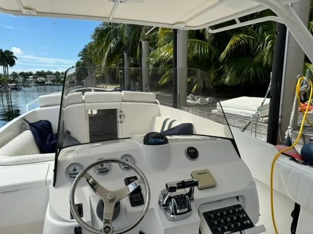 Galore Yacht Photos Pics 2006 Intrepid 323 Cuddy boat interior with steering wheel and dashboard, docked near palm trees.
