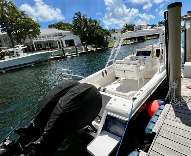 Galore Yacht Photos Pics 2006 Intrepid 323 Cuddy boat docked by waterfront homes under a sunny sky.