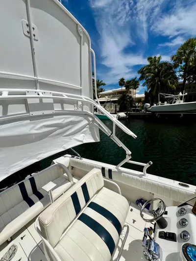 Galore Yacht Photos Pics 2006 Intrepid 323 Cuddy boat interior with striped seating, docked by palm trees.