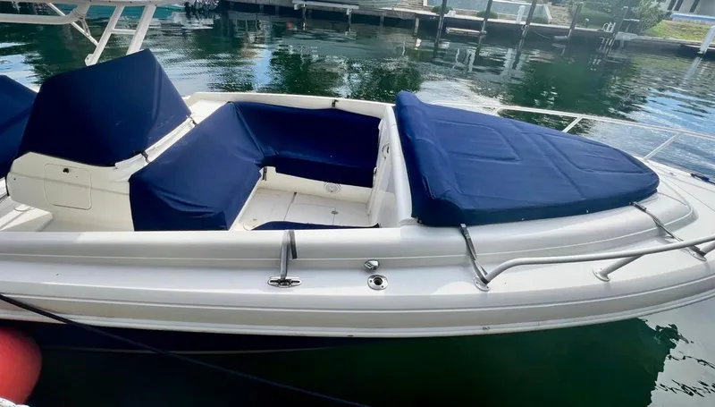 Galore Yacht Photos Pics 2006 Intrepid 323 Cuddy boat with blue seating, docked on calm water.