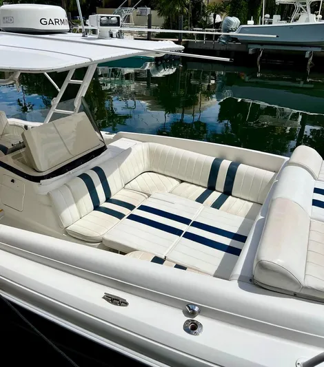 Galore Yacht Photos Pics 2006 Intrepid 323 Cuddy boat with white and blue seating, docked in a marina.