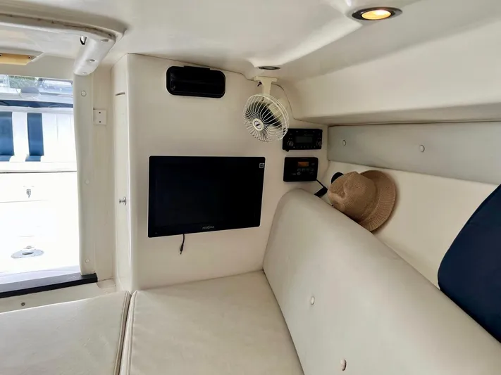 Galore Yacht Photos Pics Interior of 2006 Intrepid 323 Cuddy with TV, fan, and seating area.