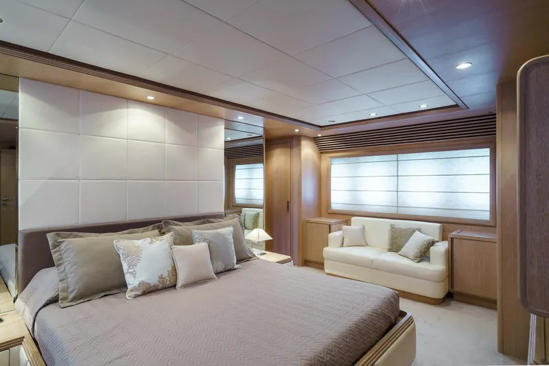 Allie Yacht Photos Pics Luxurious bedroom interior of 2008 Alalunga Open 85 Sport X yacht, featuring elegant decor and cozy seating.
