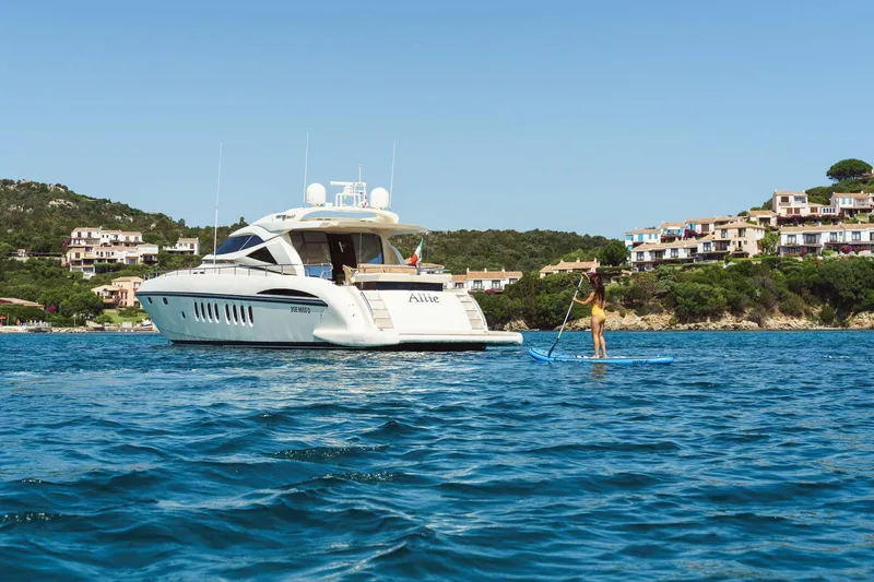 Allie Yacht Photos Pics Luxury yacht Alalunga Open 85 Sport X, 2008, with paddleboarder in scenic coastal waters.