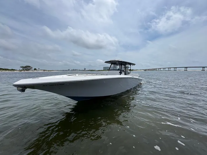  Yacht Photos Pics 2022 Fountain 38TE boat on water with bridge in background under cloudy sky.