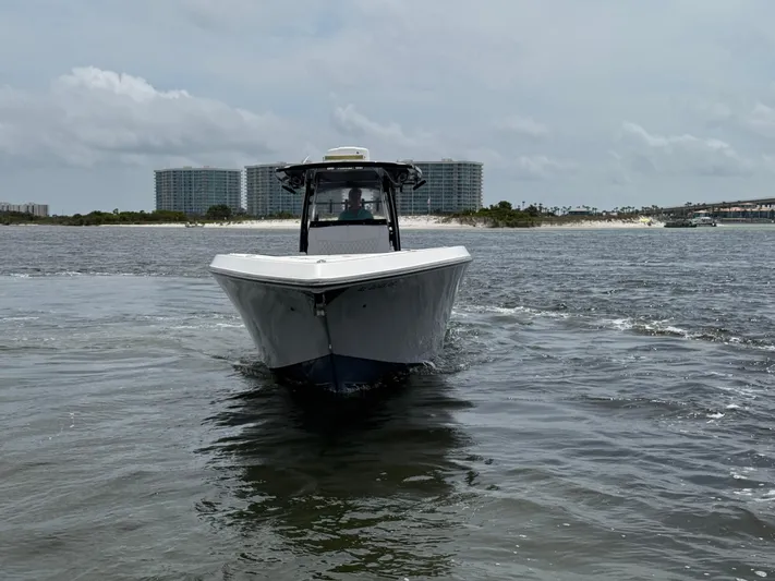  Yacht Photos Pics 2022 Fountain 38TE boat cruising on water with buildings in the background.