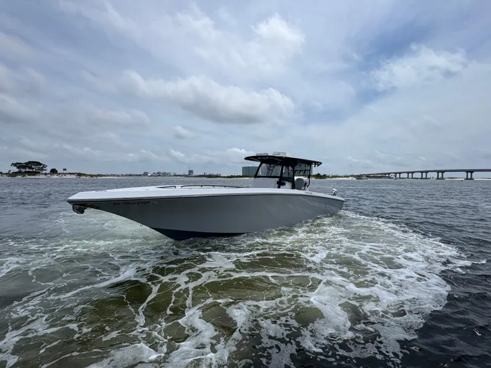  Yacht Photos Pics 2022 Fountain 38TE boat cruising on open water under cloudy skies.