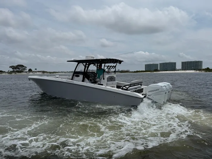  Yacht Photos Pics 2022 Fountain 38TE boat cruising on water with cityscape in background.